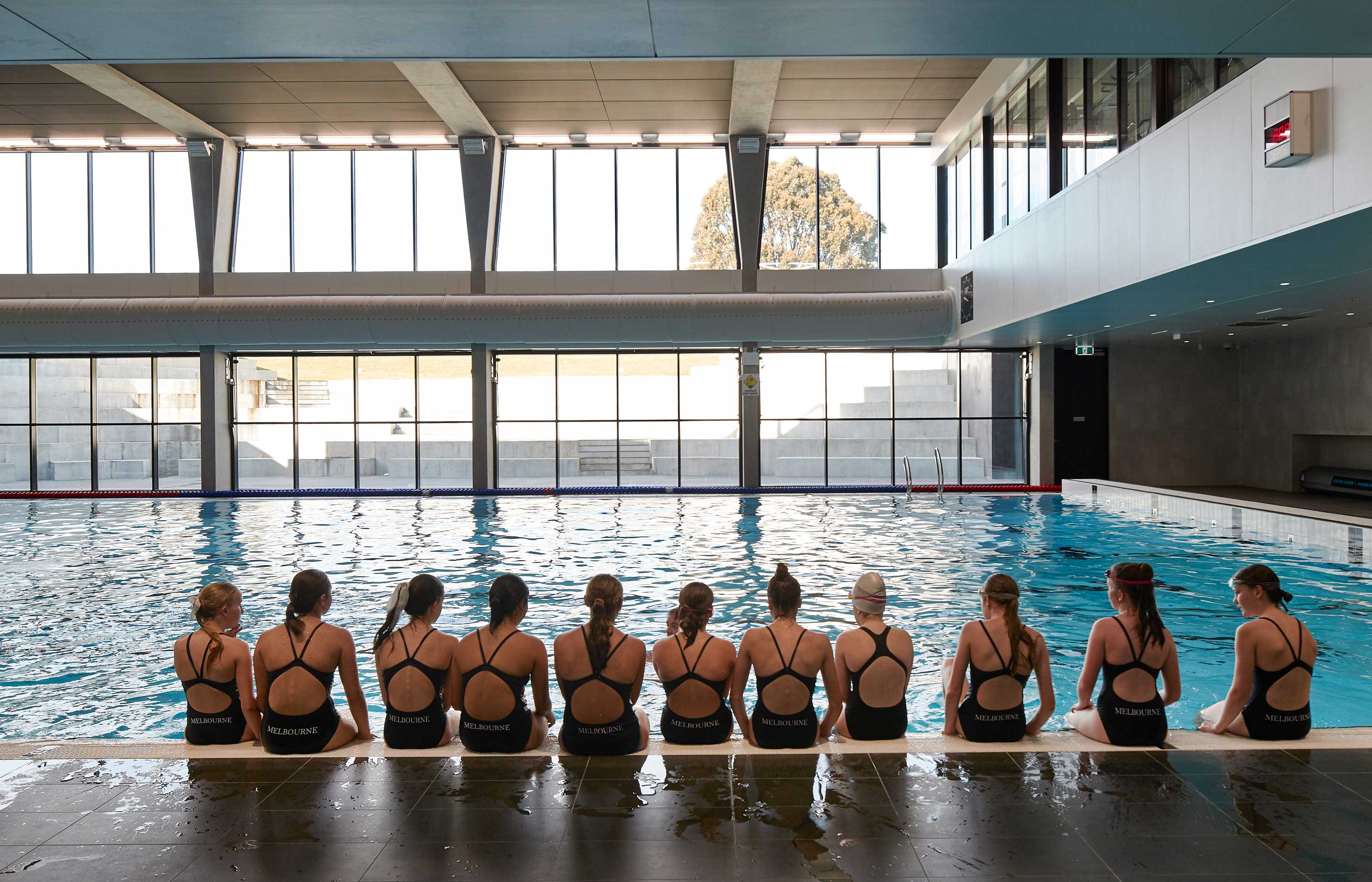 Girls sitting pool side 